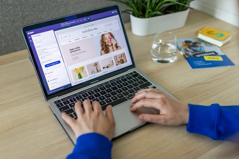 Hands typing on a laptop showing an online store's product page